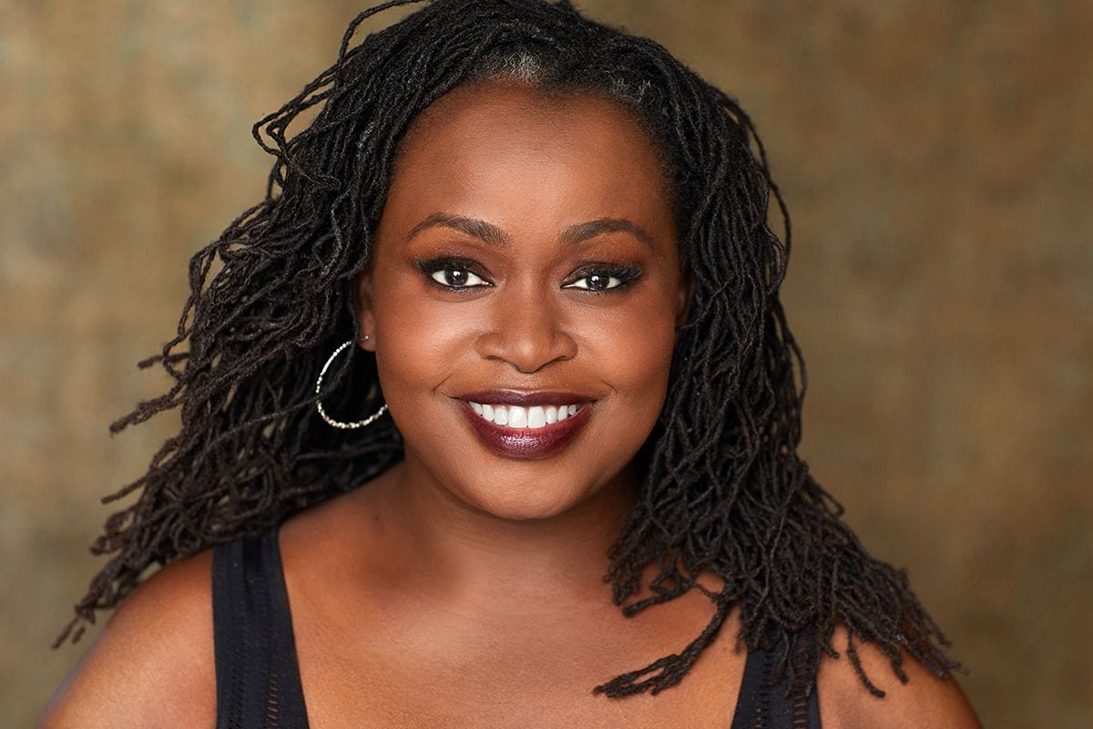 Anyumel Rose, comedian and performer, smiling in a professional studio headshot
